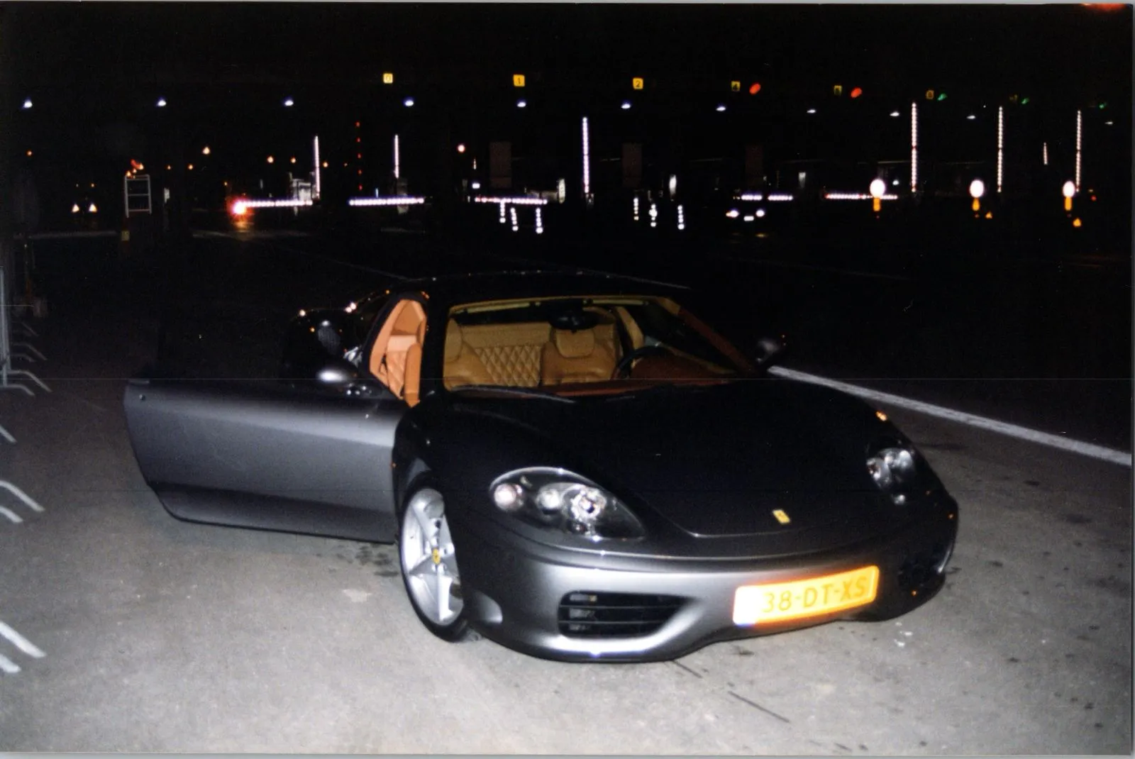 The grey 360 at night with an open door, tan interior and Dutch plate 38-DT-XS