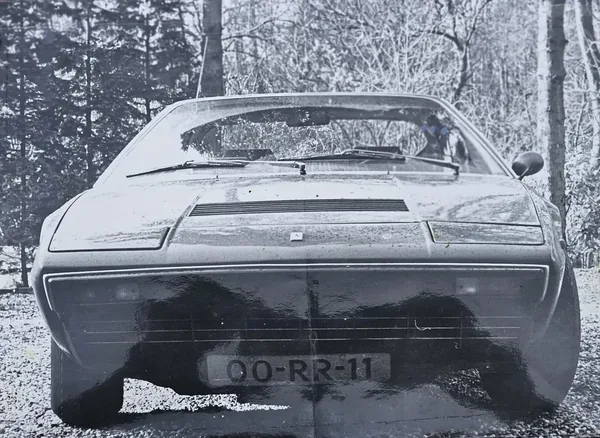 Black-and-white photograph of the 308 GT4 from the front, with registration 00-RR-11 beneath the grille