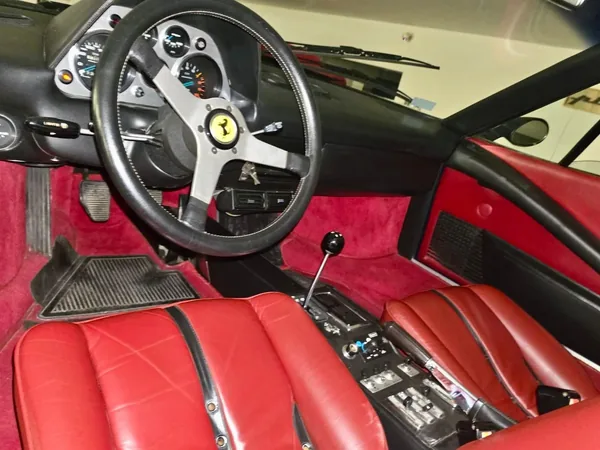The red 308 cabin with dark seat inserts and an open gearshift gate