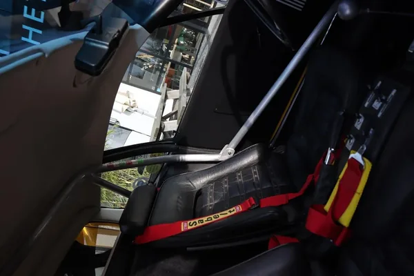The Boxer’s cabin with a black bucket seat, red harness and roll-cage tubing