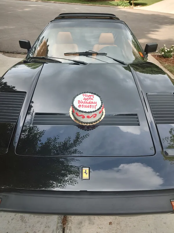 A cake iced Happy 40th Birthday #51665 on the black front lid of the 308